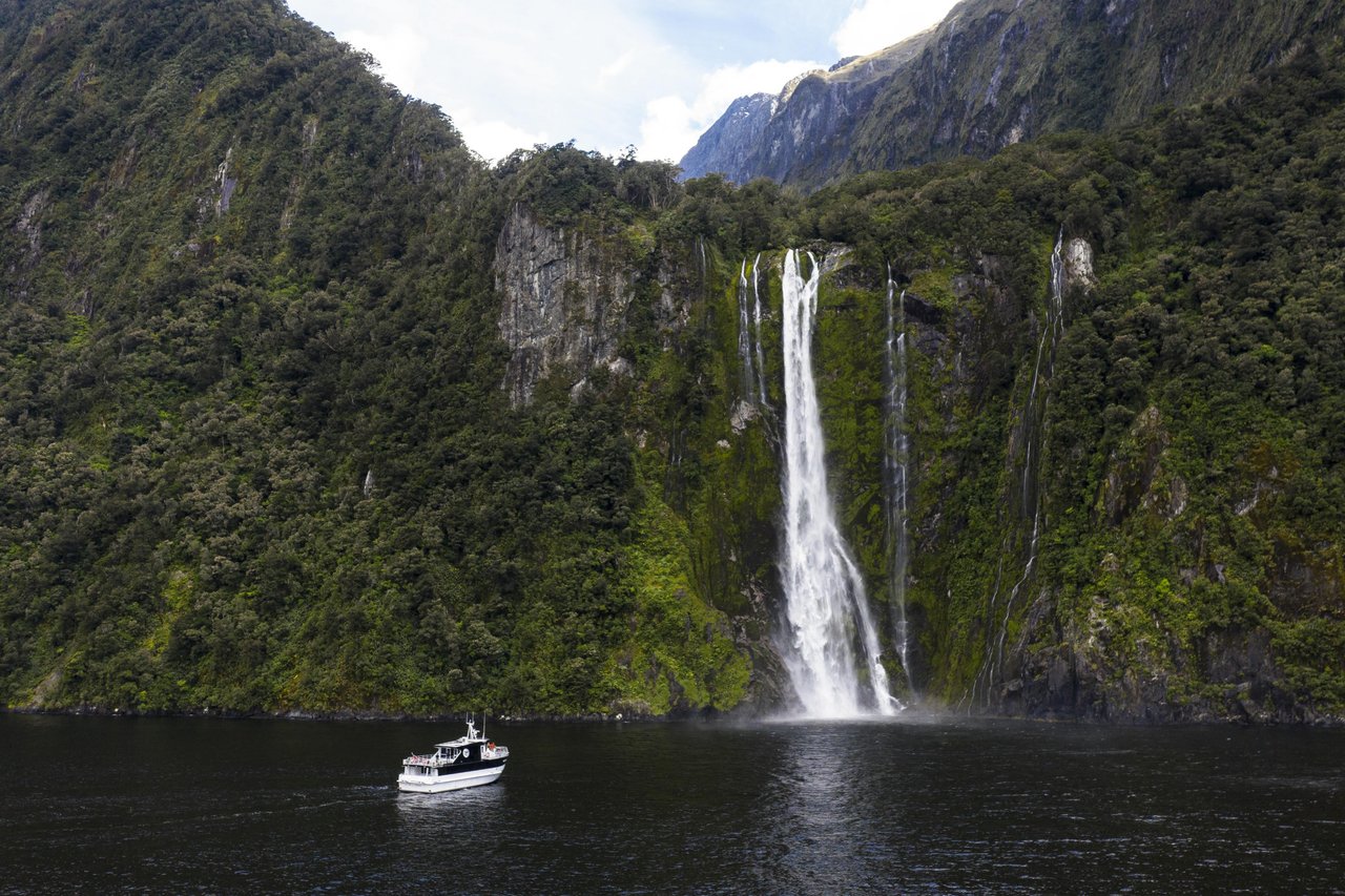 Milford Sound boat under waterfall