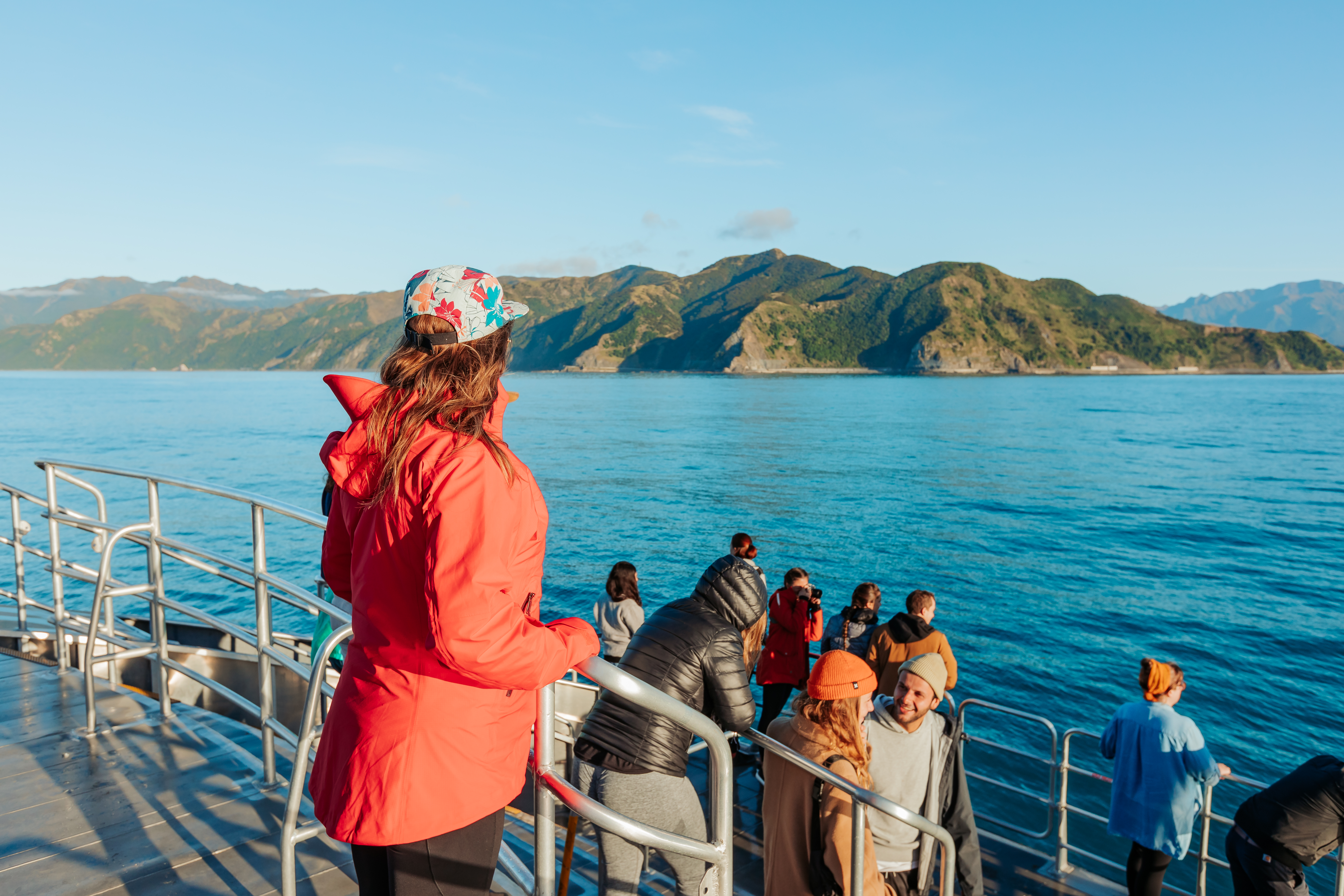 people standing outside on boat decking watching for whales in kaikoura