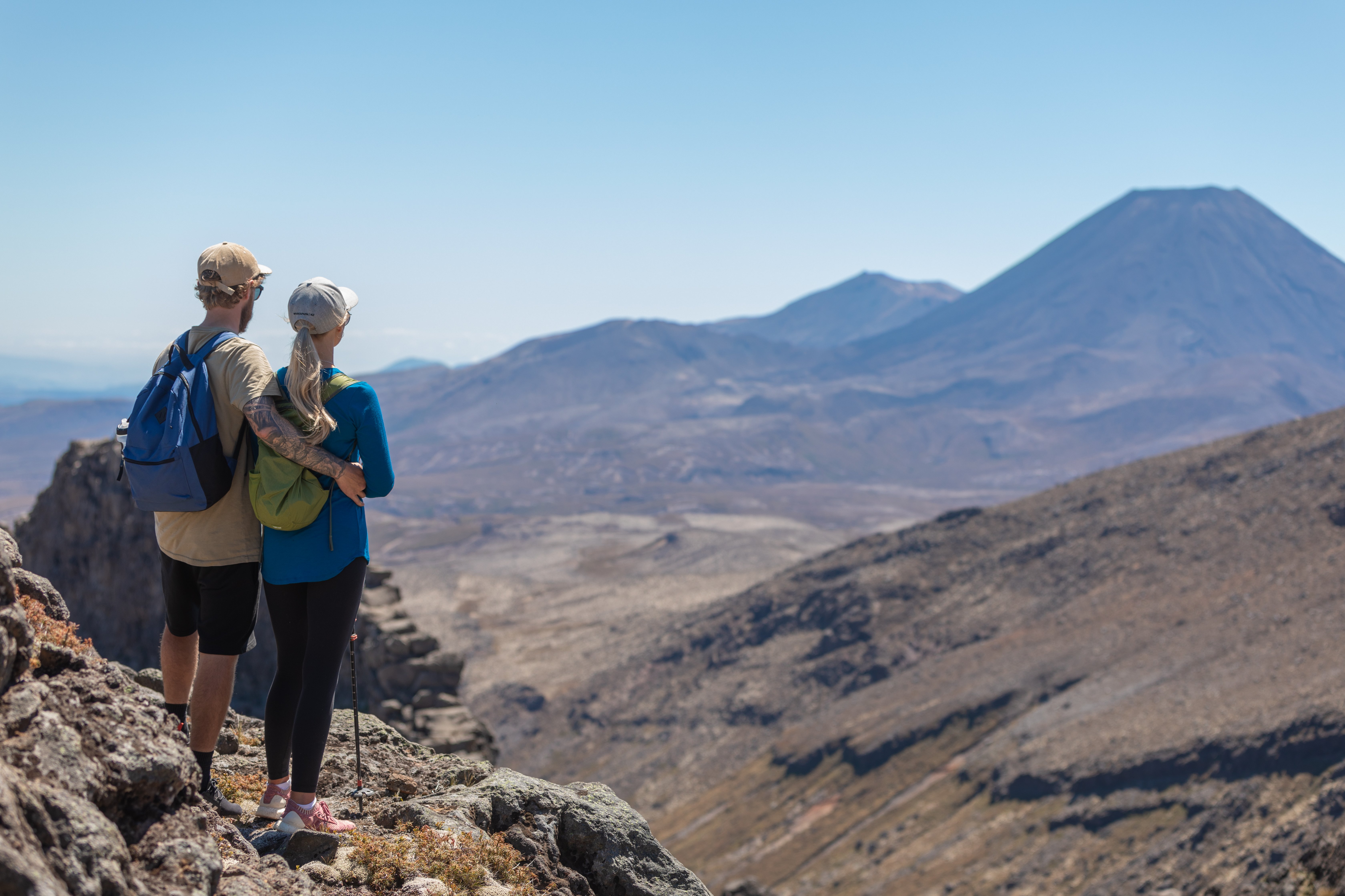 Couple standing on Mt Ruapehu looking at Mt Ngauruhoe